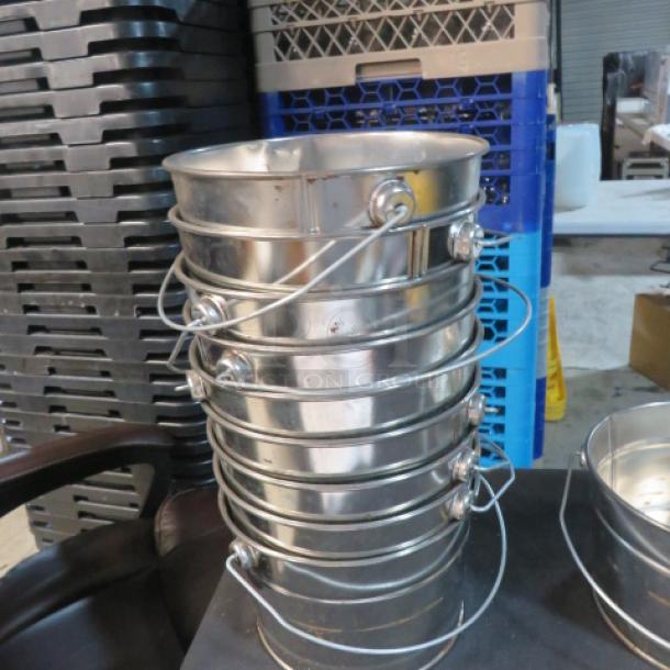 A stack of shiny tin buckets, 7x5 inches, with sturdy metal handles, excellent condition. Ideal for multi-purpose use.