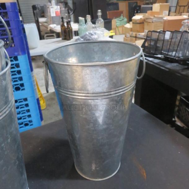 Galvanized bucket, 7x10.5 inches, metal construction, with handles, in good condition, suitable for various uses.