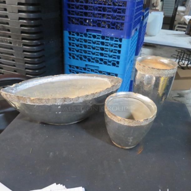 Assorted heavy pots; includes an oval, taller, and rounder pot. Metallic finish with textured rim. Used condition.