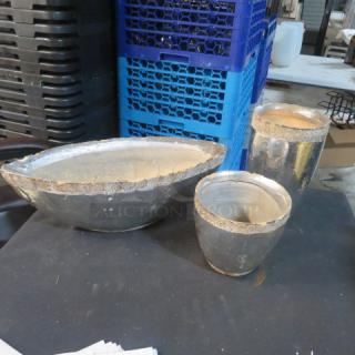 Assorted heavy pots; includes an oval, taller, and rounder pot. Metallic finish with textured rim. Used condition.
