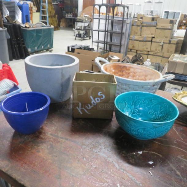 One lot of miscellaneous items includes ceramic pots and bowls in various colors, some with visible wear, on a wooden table.