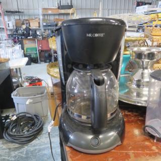 Mr Coffee machine, model VB13, in good condition. Features a glass carafe and black exterior. Visible Mr Coffee branding.