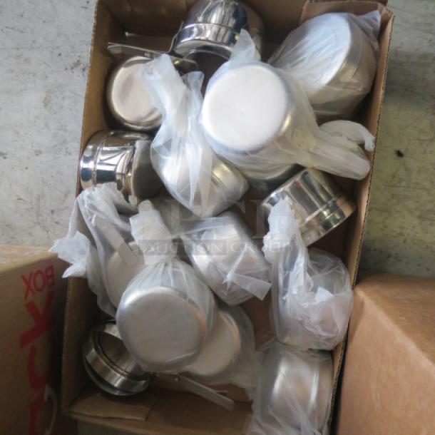 A box of new stainless steel chafer fuel holders, each individually wrapped in plastic, in excellent condition.
