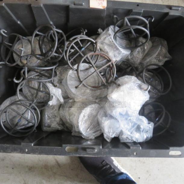 A large black container filled with black metal chafer fuel holders, some wrapped in plastic, indicating new or unused condition.