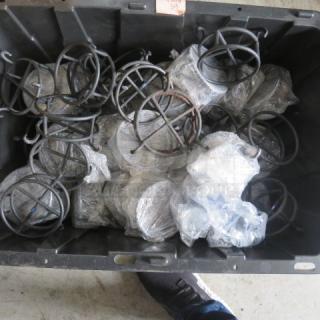 A large black container filled with black metal chafer fuel holders, some wrapped in plastic, indicating new or unused condition.