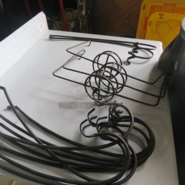 Black metal chafer fuel holders, assorted shapes, used condition, ideal for catering setups.