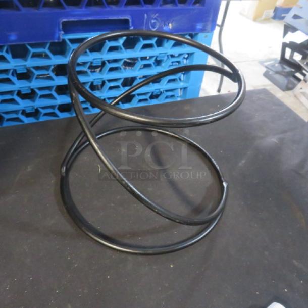 Black metal riser/holder, spiral design, assorted size, used for display or support, good condition.