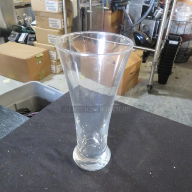 Clear Pilsner beer glass, cone-shaped design, excellent condition, no visible markings, approximately 10 inches tall.