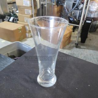 Clear Pilsner beer glass, cone-shaped design, excellent condition, no visible markings, approximately 10 inches tall.