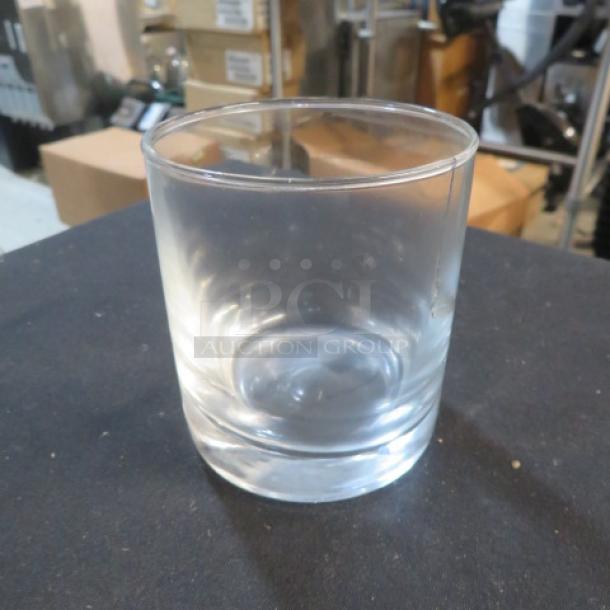 Clear double shot glass with a smooth surface and thick base, in good condition. No visible markings or labels.