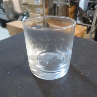 Clear double shot glass with a smooth surface and thick base, in good condition. No visible markings or labels.