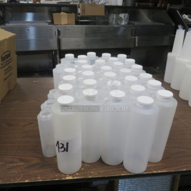 Assorted new squeeze bottles on table, varying sizes, white caps, one marked "431" with visible label.