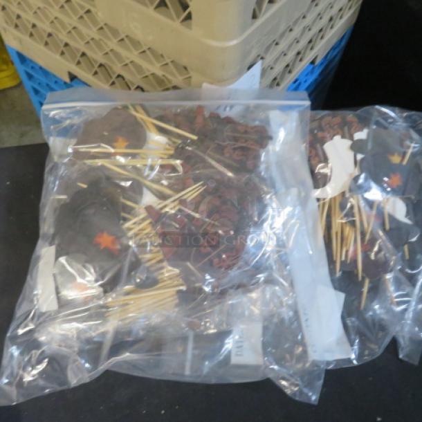 A lot of new cowboy hats and boots picks in sealed plastic bags, featuring decorative items with red star accents.