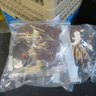 A lot of new cowboy hats and boots picks in sealed plastic bags, featuring decorative items with red star accents.