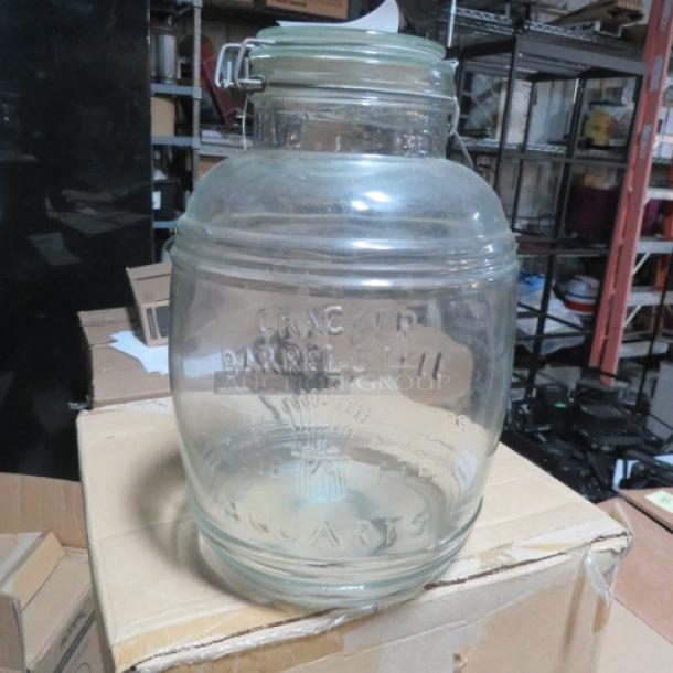 Vintage glass Cracker Barrel jar with hinged lid, embossed "Cracker Barrel" and "5 Quarts," in good condition.