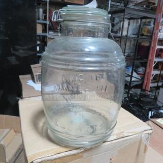 Vintage glass Cracker Barrel jar with hinged lid, embossed "Cracker Barrel" and "5 Quarts," in good condition.