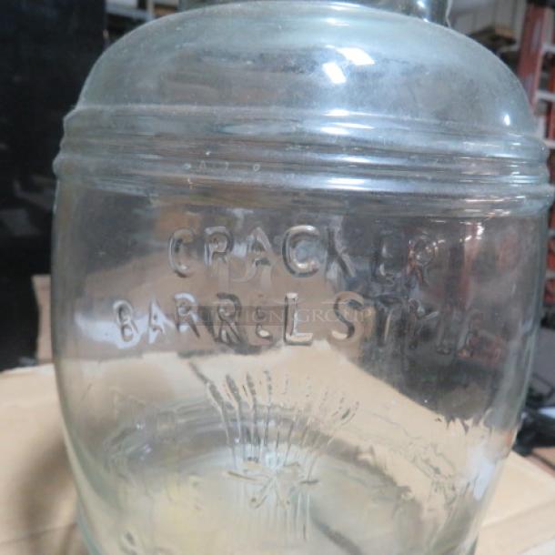 Glass Cracker Barrel jar, embossed lettering, vintage style, clear glass, used condition, barrel-shaped design.