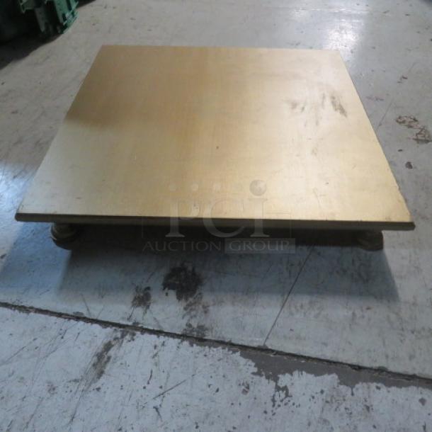 Gold-painted wooden display, 22x22x3 inches, on sturdy feet. Slight wear visible. Ideal for showcasing items.
