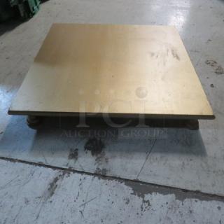 Gold-painted wooden display, 22x22x3 inches, on sturdy feet. Slight wear visible. Ideal for showcasing items.