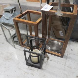 Assorted lanterns, varying sizes and materials, including metal and wood frames. Includes candles, showing moderate wear.