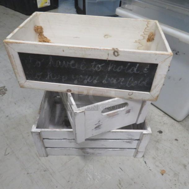 Assorted wooden decor boxes with rustic white finish, chalkboard fronts, handles, and varying sizes; slightly distressed condition.