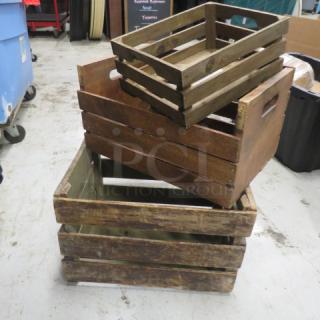 Three assorted wooden decor boxes in rustic condition, varying sizes, utilitarian handles, stacked on a concrete floor.