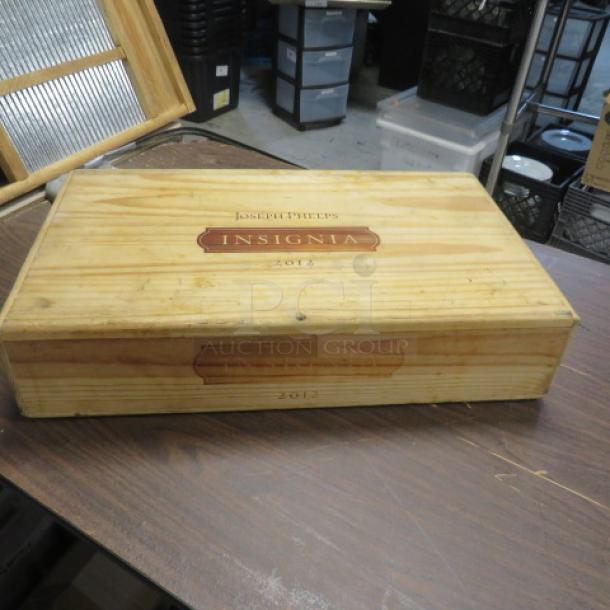 Wooden Joseph Phelps Insignia box from 2012, well-preserved with branded lid and visible vintage markings.