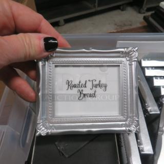 Silver picture frame with ornate design, labeled "Roasted Turkey Breast," held by a hand. Part of a large lot.