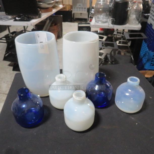 Assorted vases collection; includes large opaque white vases and small blue and white round vases in good condition.