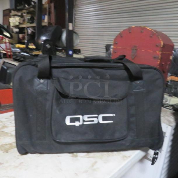 QSC Speaker Duffle Bag, black, durable material, with handles and front pocket, QSC logo visible, auction $120 each.