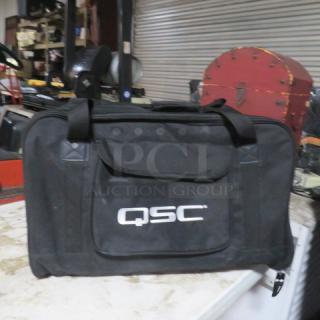 QSC speaker duffle bag, black, featuring QSC logo, sturdy handles, and zippered pocket. Excellent condition.