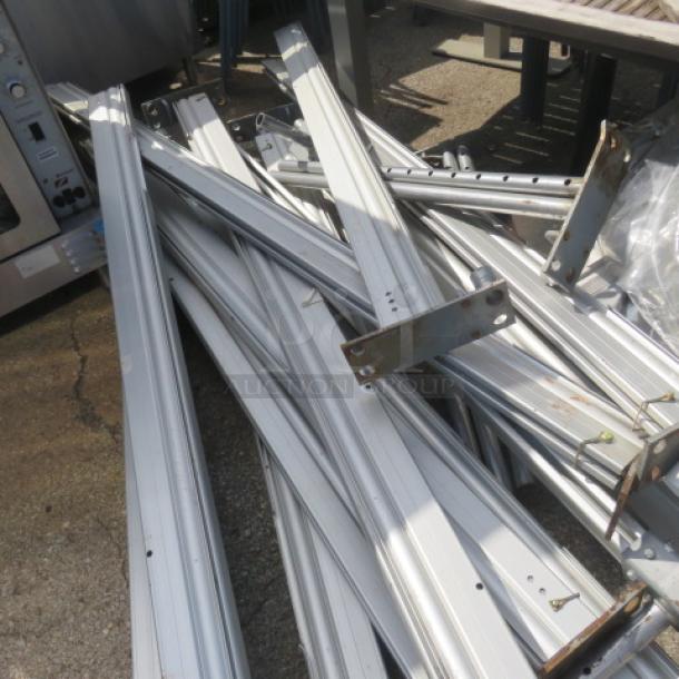 Metal frame components for one EVENT tent, used condition, stacked outdoors. No fabric visible.