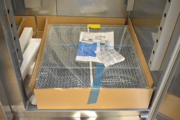 Brand new Avantco 178SS2FHC Commercial 2 Door Reach In Freezer, 115V, 1 Phase, shown in packaging with manuals and protective wrap.