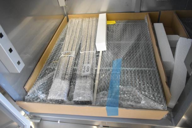 Commercial freezer shelves and parts in bubble wrap, labeled CFD 640020, inside a cardboard box within the Avantco 178SS2FHC model.