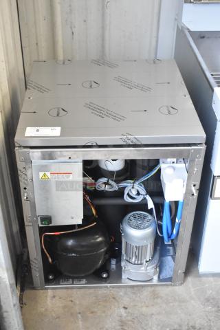 Brand new Manitowoc RNP0620A-161 nugget ice machine, 591 lb capacity, 115V, 1 phase. Visible dent on corner. Inside components shown.