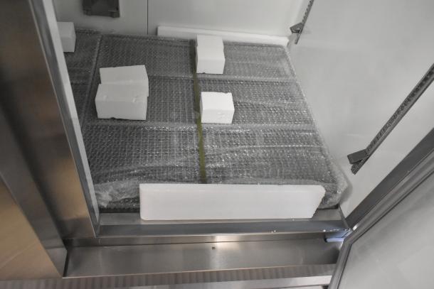 Brand new Avantco 178A49RHC commercial cooler interior, features protective packaging and adjustable shelving brackets.