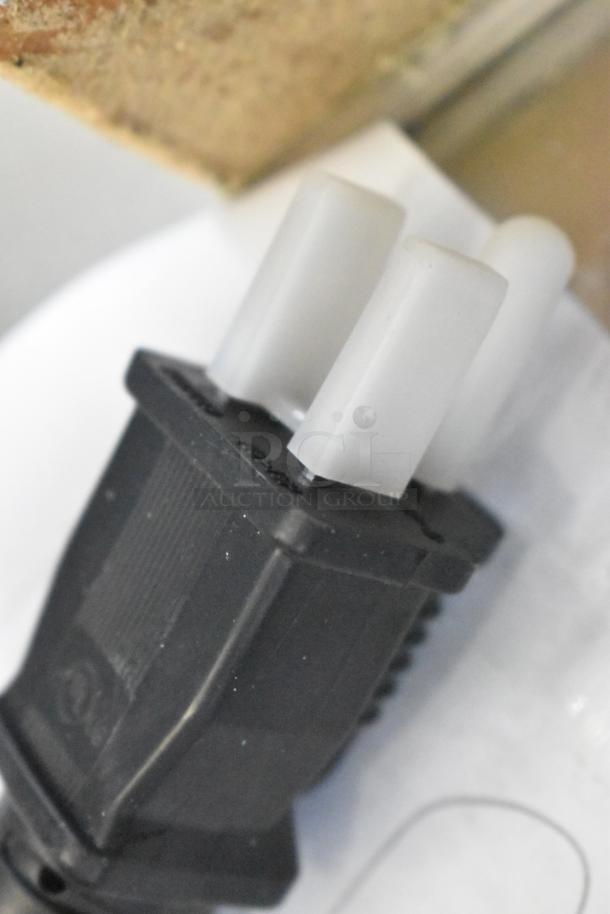 Close-up of a power plug for Avantco HPI-1836 heated cabinet. Black plastic housing, three prongs with white tips.