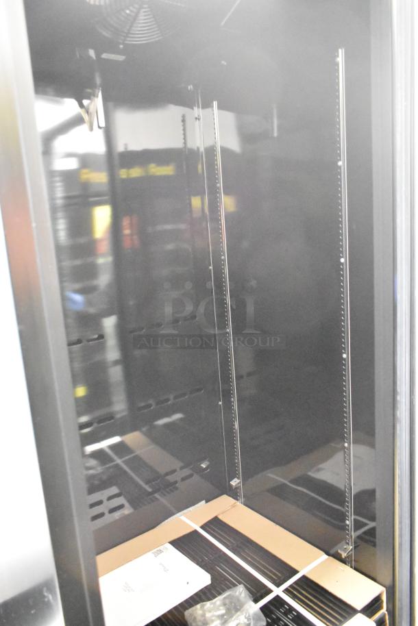 Brand new True CVM-27-HC glass door merchandiser; features LED lighting, black finish, visible broken glass; 115V, 1 phase.
