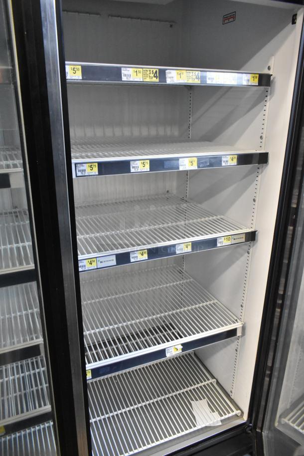 True GDM-72F-LD commercial 3-door reach-in freezer merchandiser, steel shelves, visible pricing labels, 115V, 1 phase.