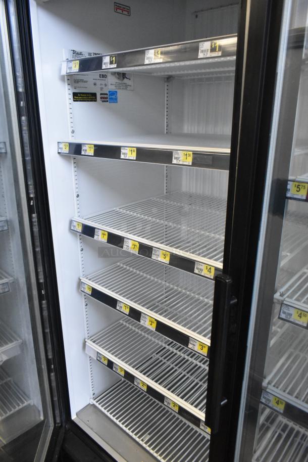 True GDM-72F-LD commercial 3-door reach-in freezer merchandiser, 115 volts, 1 phase, with adjustable shelves and visible product pricing labels.