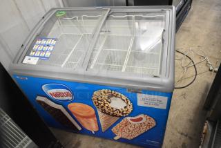 AHT RIO S 100 ice cream chest freezer with glass lid, commercial casters, Nestle branding, 115V, 1 Phase, used condition.