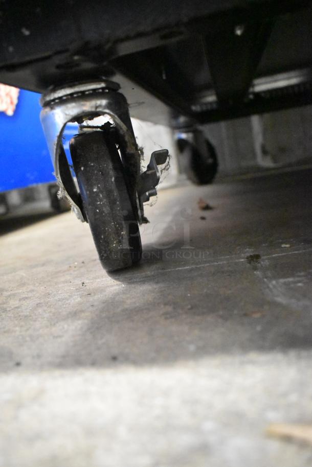2019 True T-23F-HC commercial freezer on casters; close-up of commercial caster showing wear and debris.