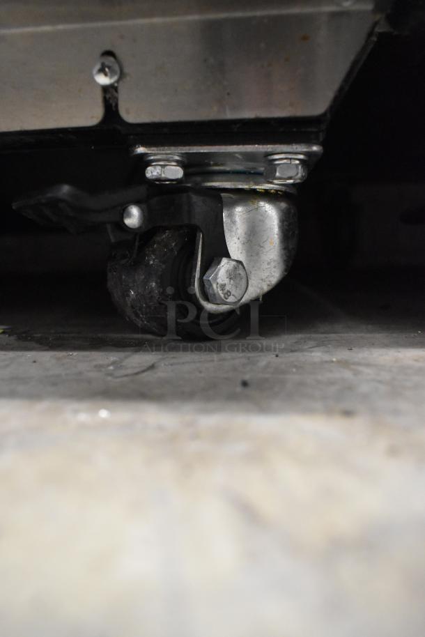 Kratos 68K-774HC commercial freezer caster, metal and rubber construction, part of reach-in unit.