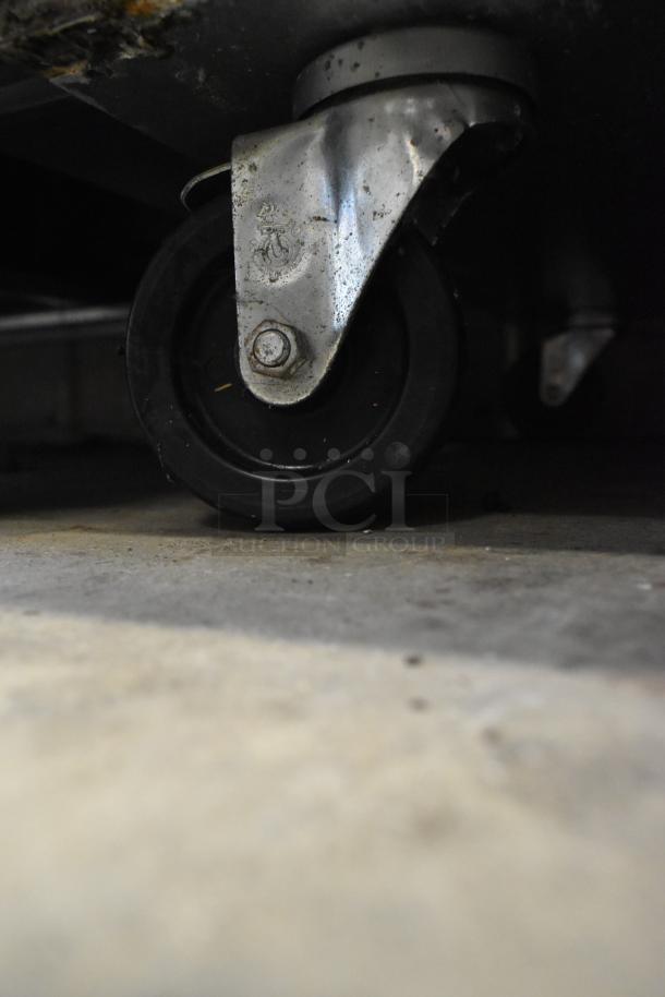 Turbo Air M3R47-2-N cooler caster wheel, showing metal frame and condition, part of a commercial 2-door reach-in cooler.