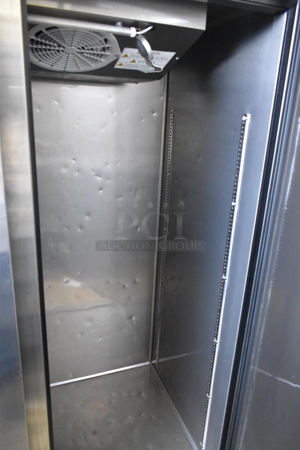 Turbo Air M3F47-2-N commercial 2-door freezer interior, stainless steel with visible shelving brackets and fan, on casters.