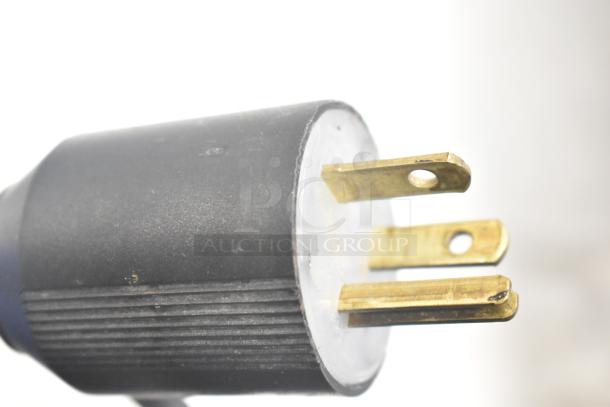Close-up of a three-prong electrical plug of the Lasbem HZ0.2L2-CPL, showing clean and well-maintained brass connectors.
