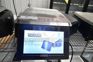 2017 Hobart HTi-7LH26 metal food portioning scale, no power cord, tested working, visible display screen, auction tag.