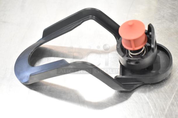 Black and red plastic component on a metallic surface, part of Narvon 378RBD5G3 beverage dispenser.