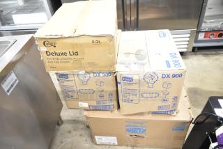 Four boxes including Choice Deluxe Lid for 8 Qt Chrome Roll Top Chafer, Tork DX900 Napkins, and Zurn Mop Basin, stacked.