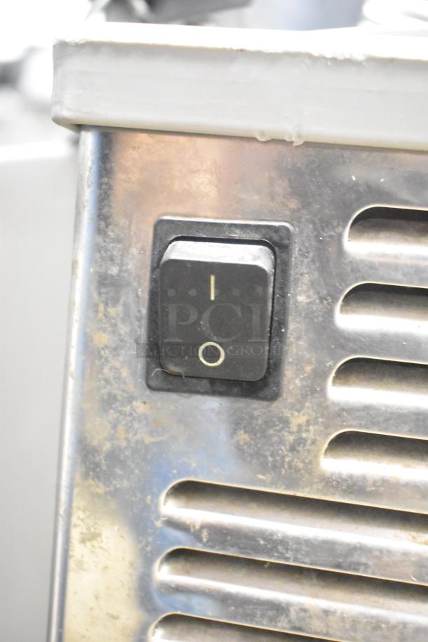 Zummo Z14C commercial countertop citrus juicer, 110 volts, showing on/off switch, part of stainless steel exterior.